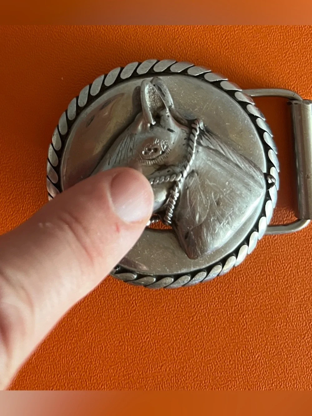 Vintage western-style belt buckle features a sculpted horse head,